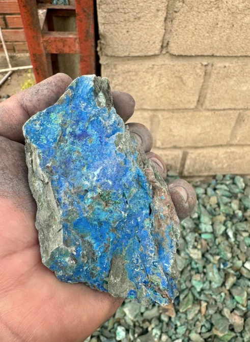 Hand holding a copper ore sample on site