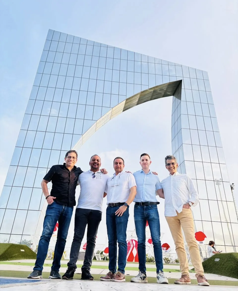 Recursos Corporativos team gathered beneath a modern architectural arch